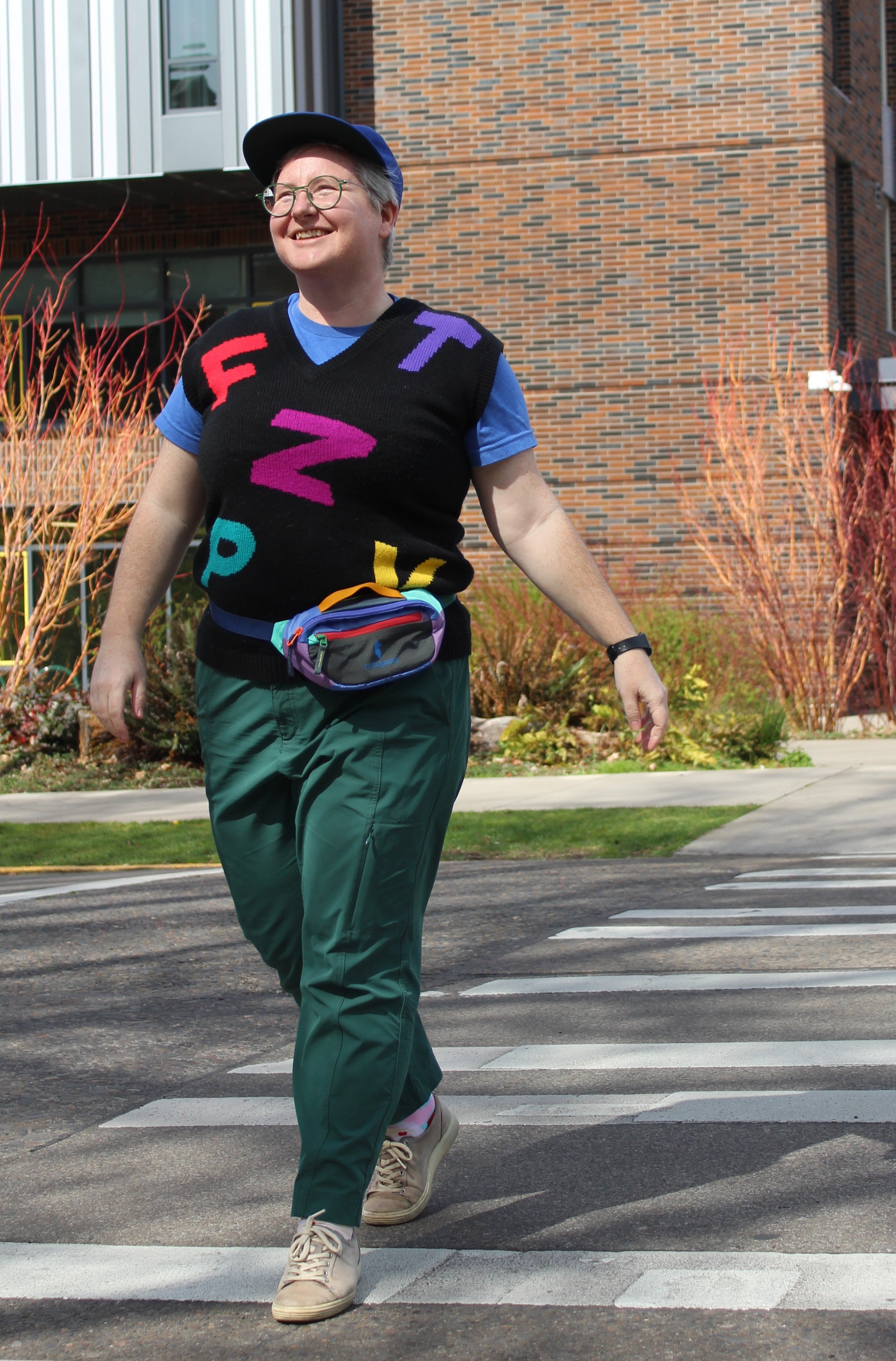 UO employee walking on campus wearing a Cotopaxi hip pack